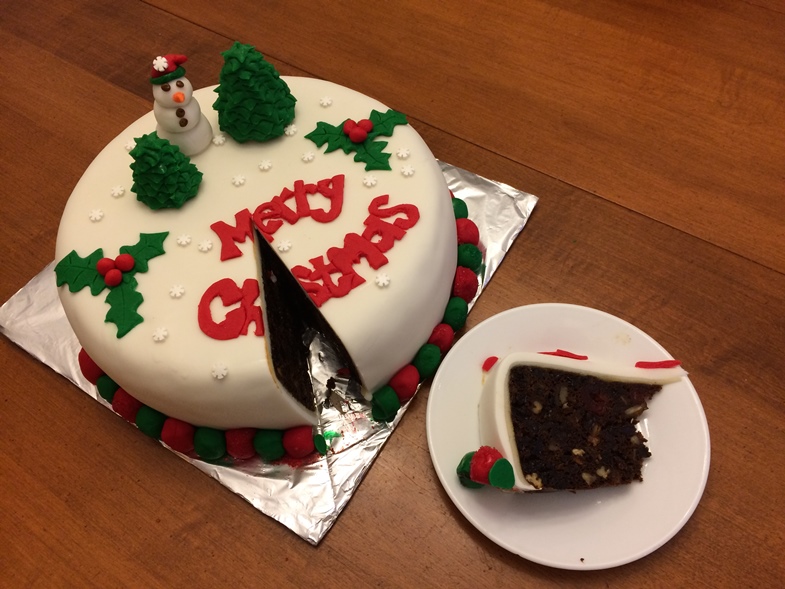 Gluten-free Christmas fruitcake with a slice cut out of it. 